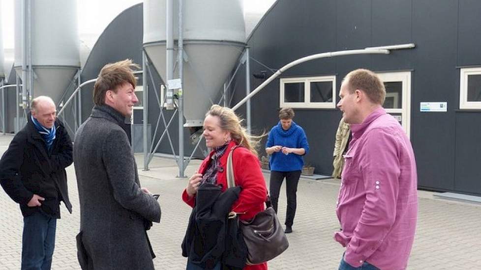 In Lemelerveld bezocht de delegatie de varkenshouderij van Herbert (paarse blouse) en Anne-Marie (blauwe trui) Noordman met 5.000 vleesvarkens. Bijzonder is dat de dieren leven in de enkele jaren oude serrestallen met ronde daken en veel lichtinval.