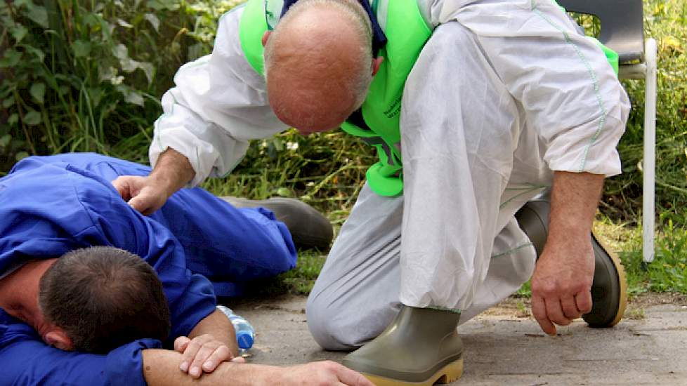 Een man op de erfgrens van een varkensbedrijf in Beers (NB) krijgt Eerste Hulp van medewerkers van de NVWA, in dit geval een hygiënist die BHV heeft.